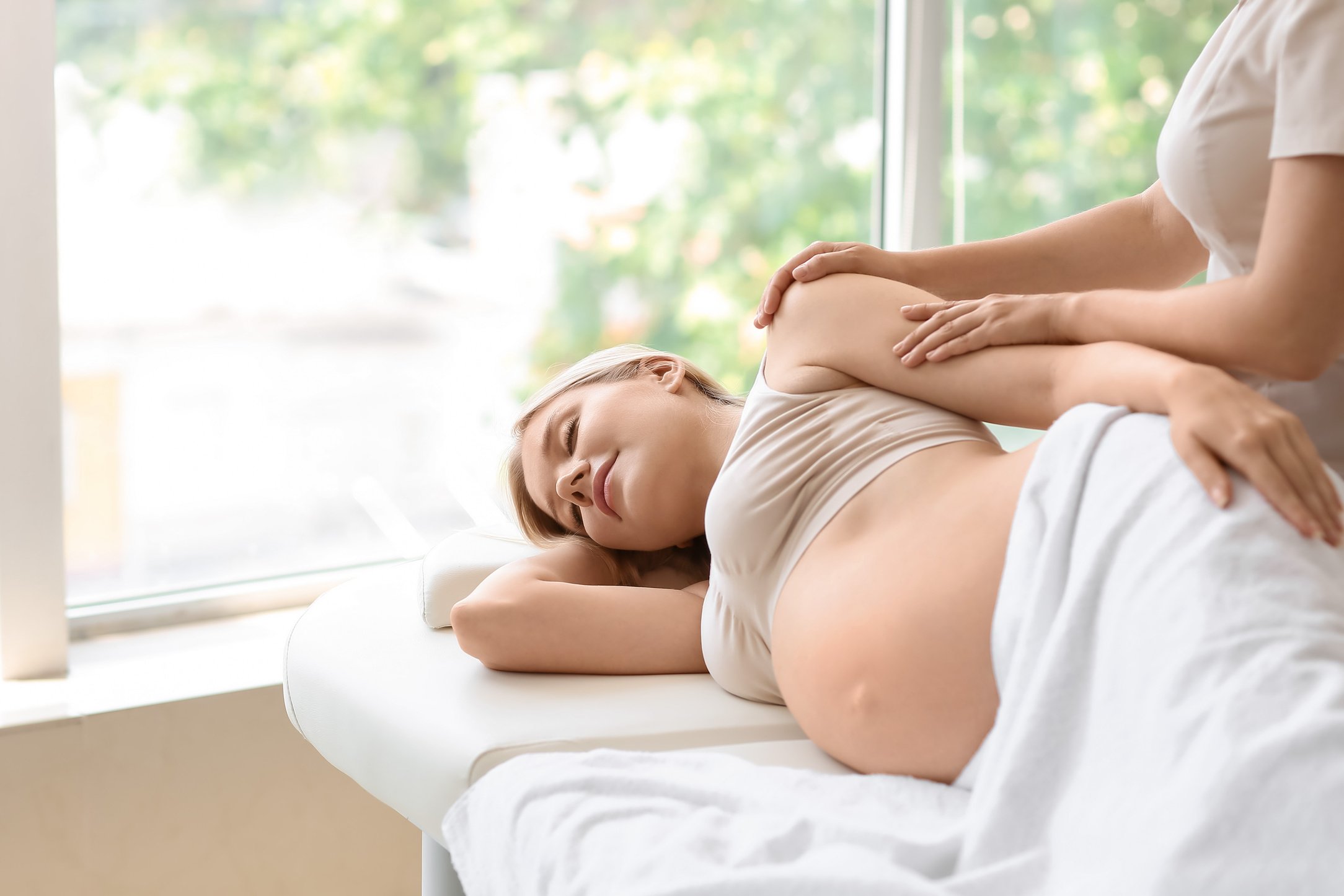 Young Pregnant Woman Having Massage in a Spa